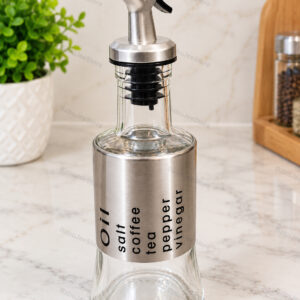 Glass oil and vinegar dispenser with pourer and stainless-look sleeve