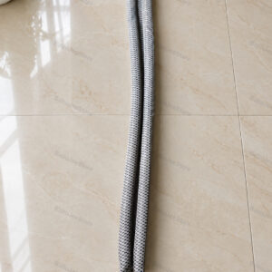 Grey patterned double-sided door-bottom stopper laid out on a tiled floor
